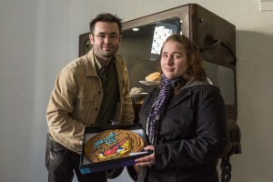 Autor projektu Zlatokop Henry® Patrik Hořelica předává Královské cookie (s trilobitem)  autorce rebelské videopozvánky Královská hostina. Jana Szkanderová je další mladá talentovaná umělkyně, která obohatila Království Zlatokopa Henryho.